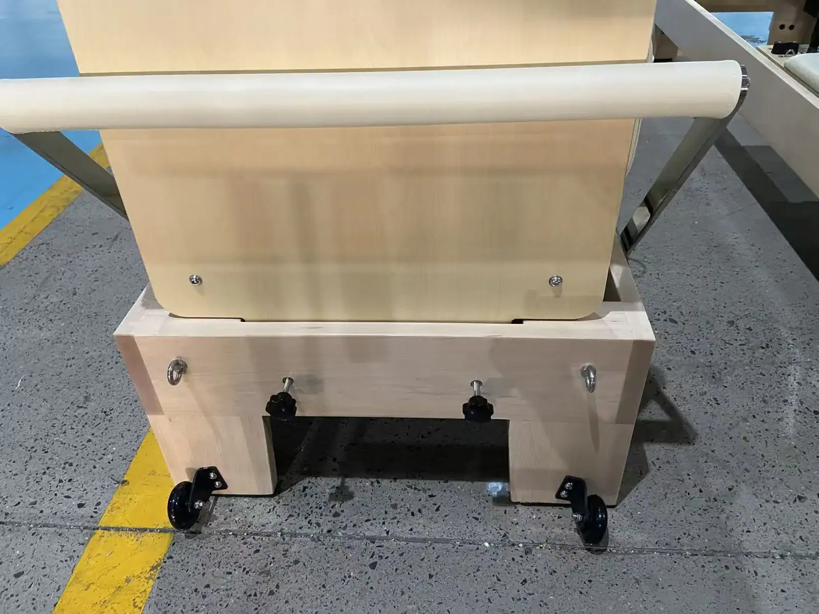 Rear transport wheel detail on a WD-MS-003 wooden Pilates reformer