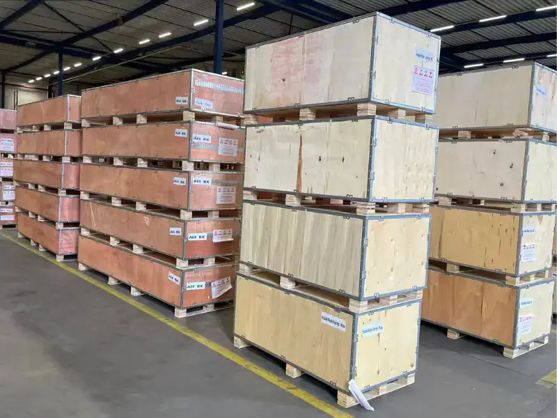 Finished Pilates reformers stored in wooden shipping crates at a manufacturing partner facility