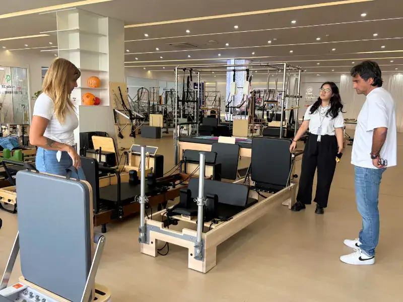 Buyer testing Pilates reformer movement and hardware