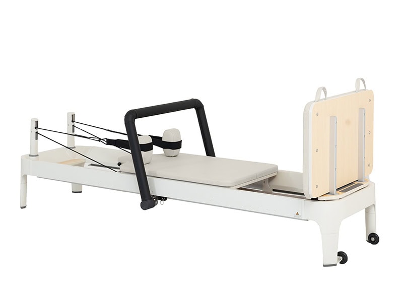This white aluminum sleek and modern Pilates Reformer features a cushioned carriage, adjustable footbar, and durable resistance cords—perfect for enhancing strength, flexibility, and core stability in any home or studio setting.