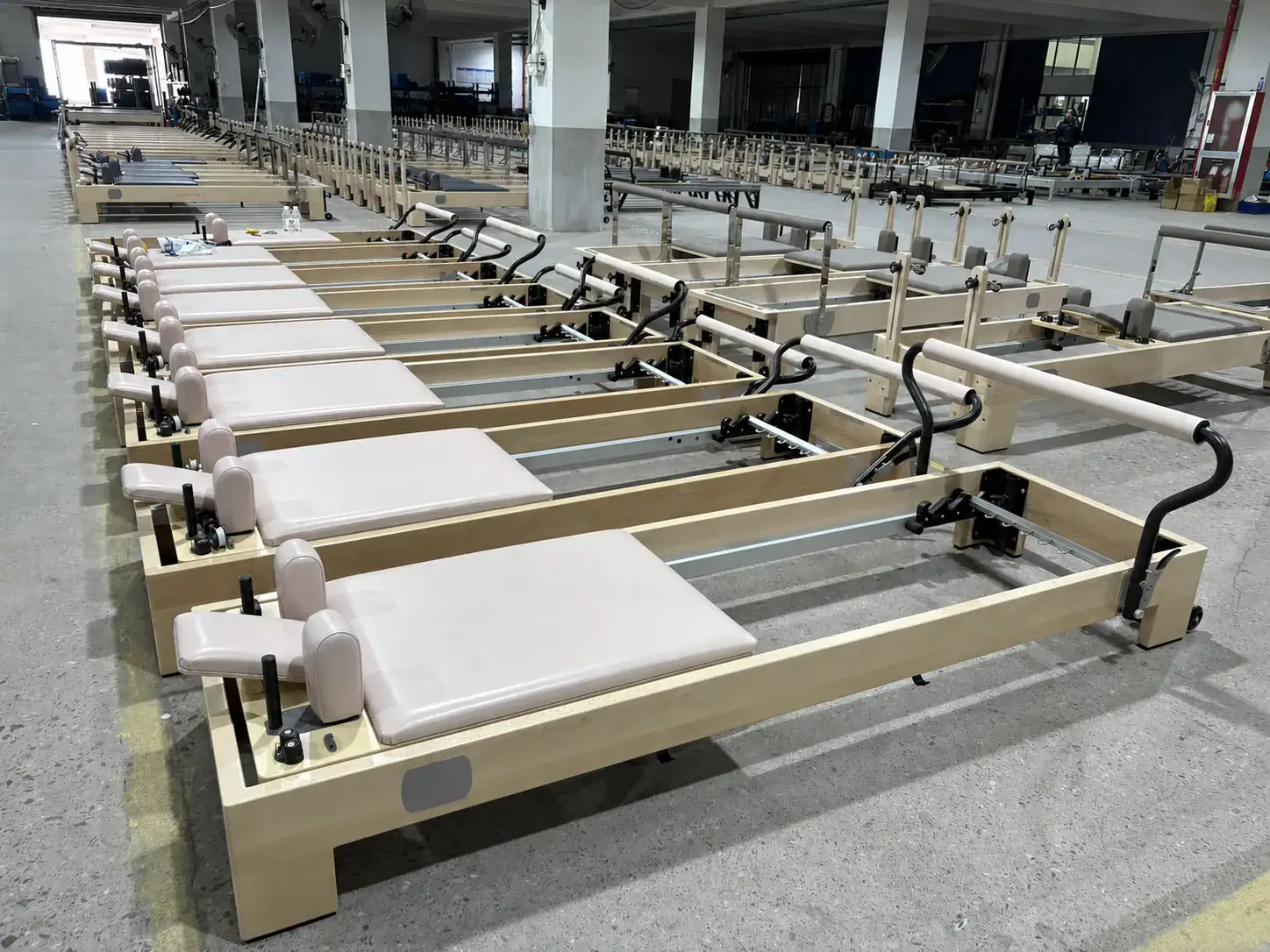 Custom WD-MASTER-004 maple Pilates reformers with light pink upholstery for a German multi-location studio