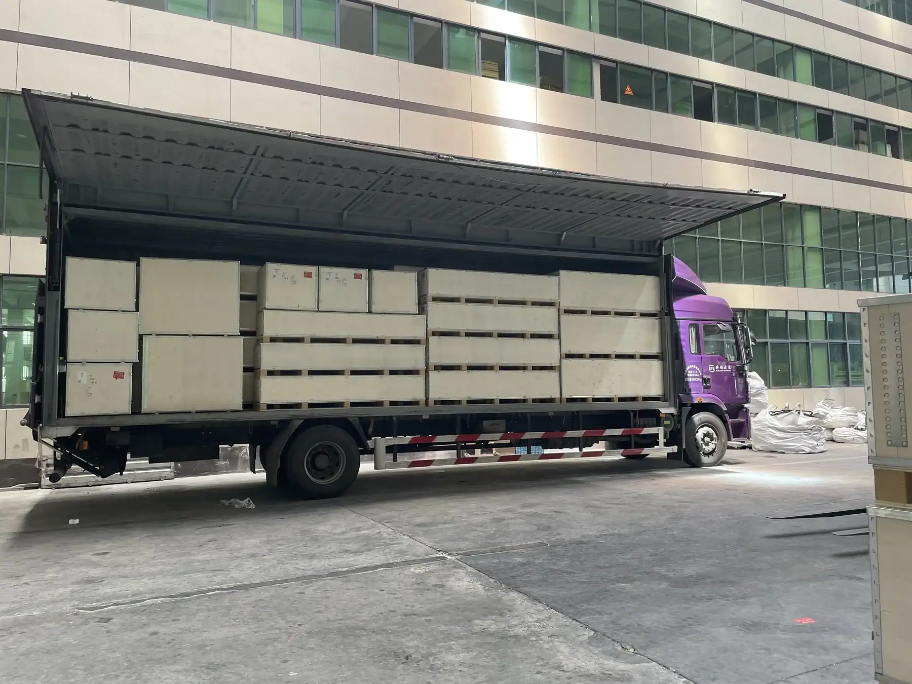 Export crates of wholesale Pilates reformers being loaded onto a truck.