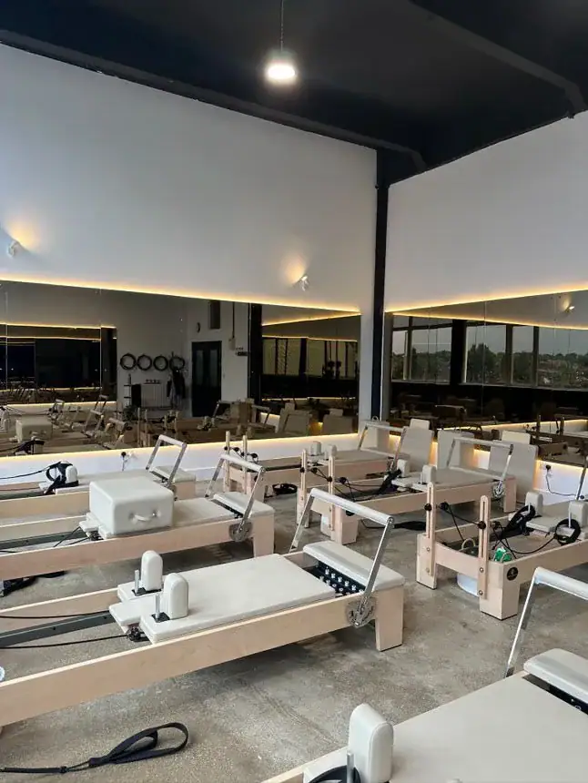 Maple Pilates reformers arranged in a UK group studio